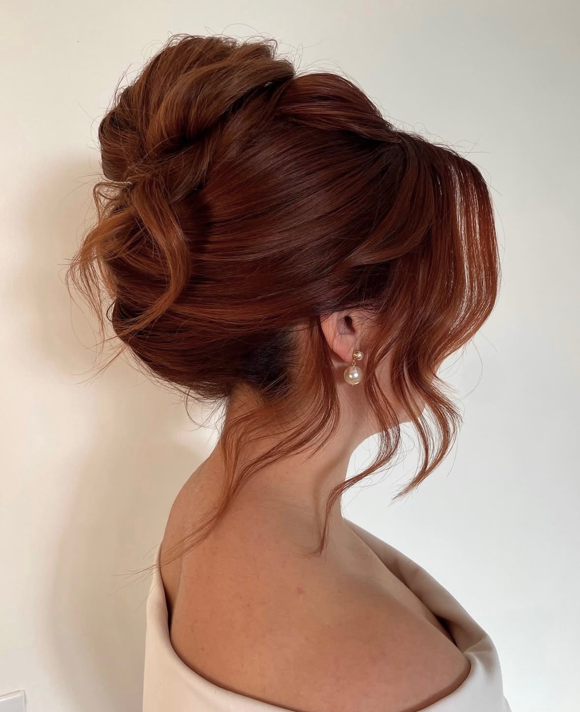 chic high updo on beautiful red hair with pieces falling and face framing